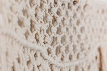 Detail of cream macrame decor displayed hanging on a wall. - obrazy, fototapety, plakaty