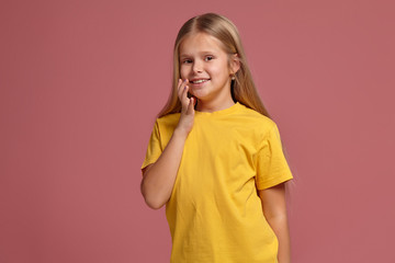 little girl in a yellow t-shirt. looking shyly