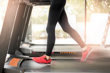 Close up of  woman's muscular legs feet running on treadmill workout at fitness gym, Healthy lifestyle