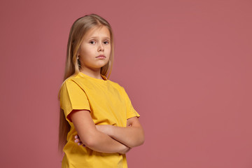 little girl in a yellow T-shirt. looks offended