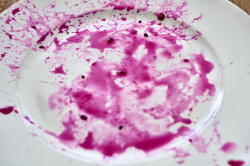 Splashes of juice of red pitahaya on white plate