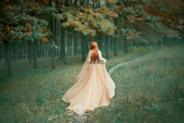 mysterious lady in long light expensive luxury dress with long trailing train runs along forest...