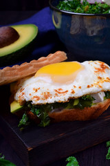 Sandwich with fried egg with liquid yolk and kale cabbage