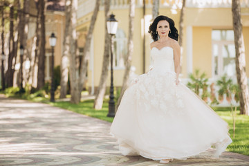 Obraz premium Beautiful bride in a white wedding dress on outdoors.
