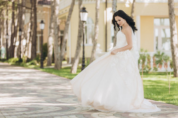 Obraz premium Beautiful bride in a white wedding dress on outdoors.