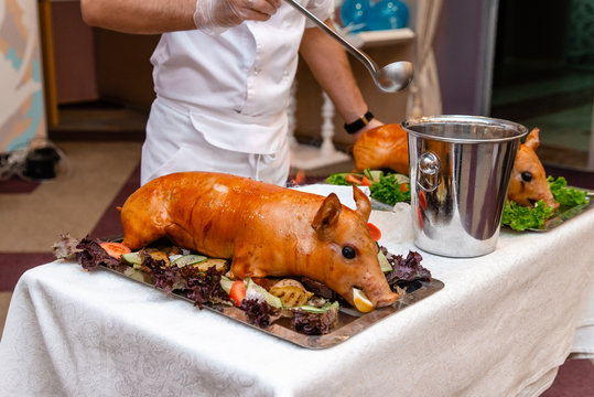 Roasted pork ready for serving. Grilled piglet with head.