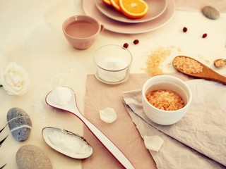  Sea salt, sliced ​​orange, sea stones and shells, water on a bright table, ingredients for a mask, scrub, gentle care procedures