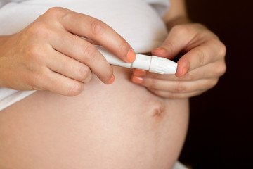 Pregnant girl monitors their health. Blood test for sugar. Diabetes pregnant.