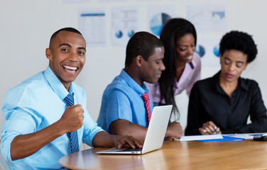 Happy african american businessman with business team at office