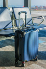 Plastic travel suitcase in the airport hall