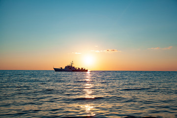 Fototapeta premium ship in sea at sunset