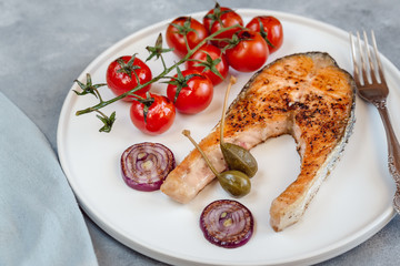 Fried salmon served with cherry tomatoes, caper apples and red onion.