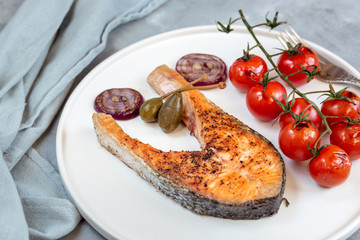 Fried salmon served with cherry tomatoes, caper apples and red onion.