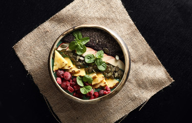 Variety of fruits with chia seeds and mint leaf.