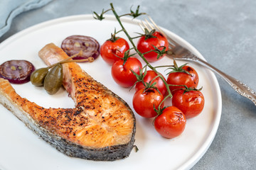 Fried salmon served with cherry tomatoes, caper apples and red onion.