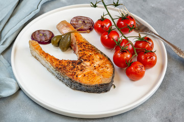 Fried salmon served with cherry tomatoes, caper apples and red onion.