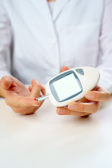 Picture of patient's hand with glucometer.