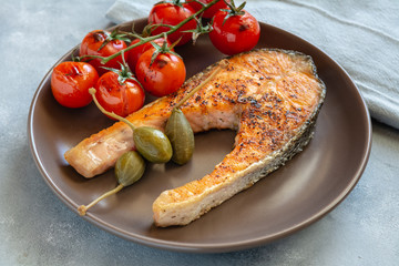 Fried salmon served with caper apples and cherry tomatoes.