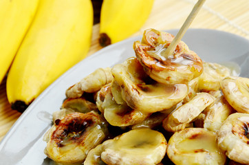 Grilled Bananas With Coconut- Caramel Sauce with fresh bananas on bamboo mat.  Banana Thai Dessert menu.