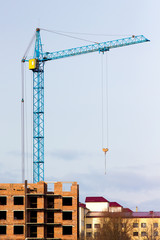 A crane at the construction of a multistory building. Construction of a modern city_