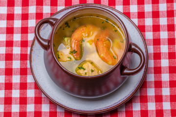 Seafood background. Macro of freshly cooked Mediterranean fish soup with salmon and shrimps in a...