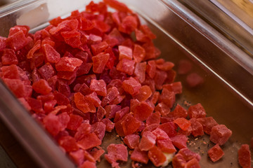 candied canned pieces of red pineapple in market mall counter food photography concept 