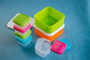 Square plastic containers with bright multi-colored lids.