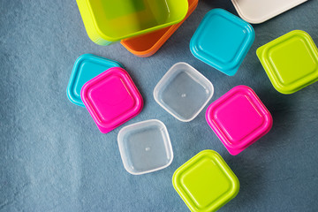 Square plastic containers with bright multi-colored lids.