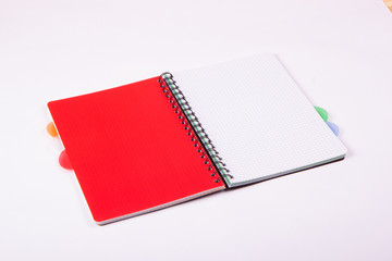 Otwarty czerwony notatnik na białym tle