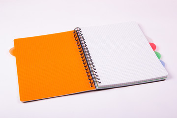 Otwarty pomarańczowy notatnik na białym tle 