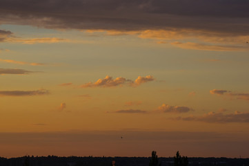 Landscape with dramatic light - beautiful golden sunset with saturated sky and clouds.