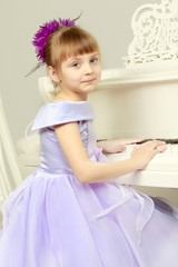A girl is posing near a white grand piano.