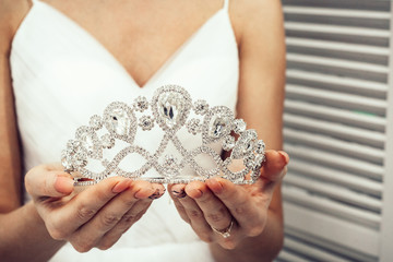 tiara in the hands of the bride on a white background © Карина Желнина