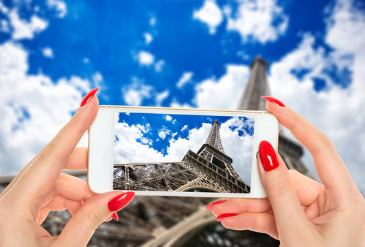 Woman taking a picture of famous Eiffel Tower in Paris