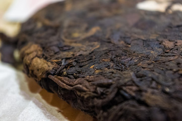 Chinese pressed puer tea on wrapping paper, close-up, macro