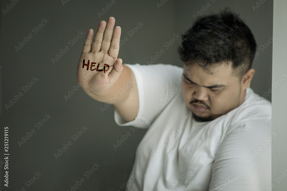 Wall mural Sad obese man showing help word - Wall murals