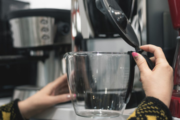 A woman is choosing a new coffee machine for home.