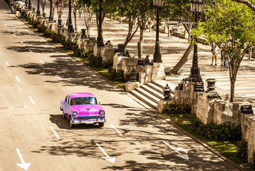 SEPIA - Amerikanischer pink Oldtimer fährt auf der Hauptstrasse Jose Marti durch Havanna City Kuba...