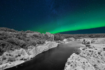 Fototapeta na wymiar View from the Roman aqueduct in France in black and white, with starry sky and northern lights