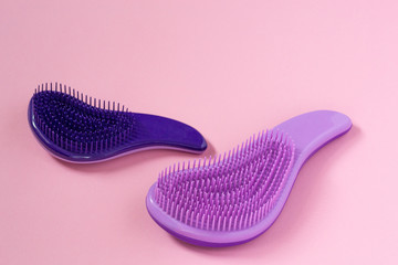 Close up female hairbrushes against hair falling for combing on pink background with copyspace....
