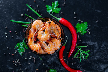 Fototapeta na wymiar Grilled prawns with chili pepper. Royal delicious and beautiful shrimp. Flatley. Food background on black stone