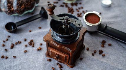 Świeżo zmielona kawa przygotowania do parzenia w otoczeniu młynka do kawy i ziarenek kawy. - obrazy, fototapety, plakaty