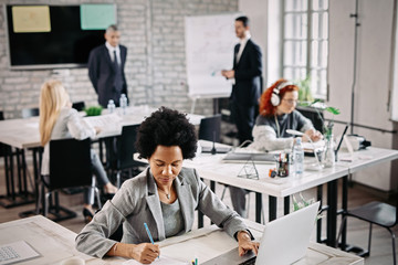 Fototapeta premium High angle view of black businesswoman working at her office desk.