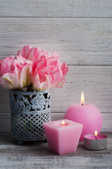 Fresh pink tulip flowers and lit candles