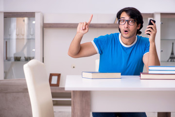 Young handsome student studying at home 