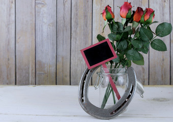 Red roses and horseshoe on wooden background for Kentucky Derby