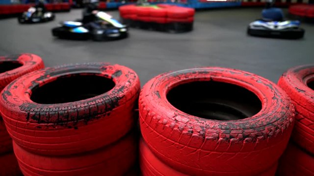 Go kart racing behind a red tire barrier