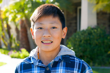 Portrait of young Asian boy with tooth braces. Young teen boy smiling and showing his orthodontic braces on his teeth.