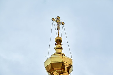 Fototapeta na wymiar Eastern orthodox crosses on gold domes, cupolas, against blue sky with clouds