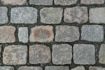 Old cobbled stone texture background, pavement structure on road.